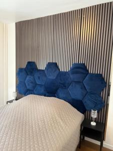 a bed with blue pillows in a bedroom at 90m2 hyper centre Sauna in Strasbourg
