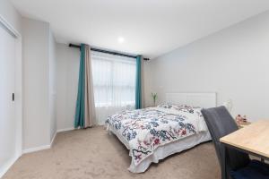 a bedroom with a bed and a window at Harborlight--Modern 2 Bedroom Townhouse in Hobsonville in Auckland