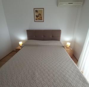 a bed in a bedroom with two lamps on tables at Soba Andela in Labinci