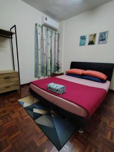 een slaapkamer met een groot bed met rode kussens bij Bayu Biru 2 Bedroom Unit Pool View Balcony in Kampong Tanah Merah