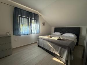 a bedroom with a bed with two cats sitting on it at Golden Wave Apartment in Vir