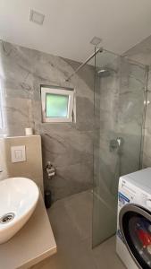a bathroom with a sink and a glass shower at Golden Wave Apartment in Vir +12 photos