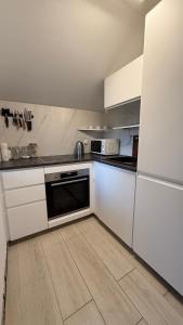 a kitchen with white appliances and a wooden floor at Golden Wave Apartment in Vir