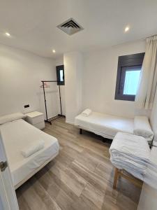 a room with two beds and a window at SM Apartments Station in Lleida