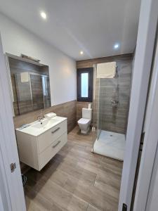 a bathroom with a toilet and a sink and a shower at SM Apartments Station in Lleida