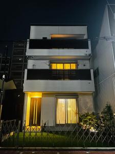 un alto edificio bianco con finestre di notte di Wa Nagoya Station Business District Downtown 3-story Luxury House with Courtyard Garden 3 Bathrooms 2 Bathrooms 2 Parking Lots a Nagoya Altre 52 foto
