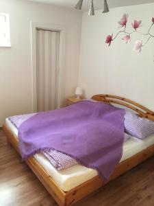 ザルツブルクにあるVilla Tusciaのベッドルーム1室(紫の毛布が敷かれたベッド1台付)