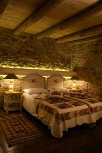 a bedroom with a bed and two tables with lamps at Argyriou Wine Tasting Guest House in Polydrossos