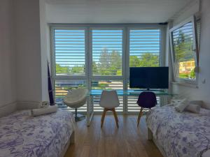 a bedroom with two beds and a desk with a television at Apartment Iva in Omiš