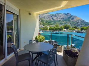 a balcony with a table and chairs and a view of the water at Apartment Iva in Omiš