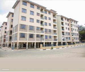 a large white building with windows on a street at Nelimah Hosts in Machakos