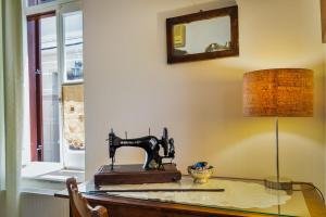 a sewing machine sitting on a glass table with a lamp at Theodorou Stone House in Pano Lefkara +33 photos