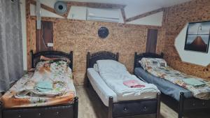 a room with two beds in a room at נוף הכפר - 6 חדרי אירוח לזוגות ומשפחות עם ג'קוזי ובריכה מחוממת משותפים במתחם in Buq‘ātā