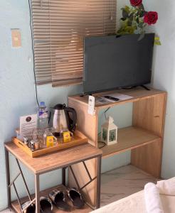 a television on a wooden stand with a table at La Evangs Beach Resort Taal in San Luis