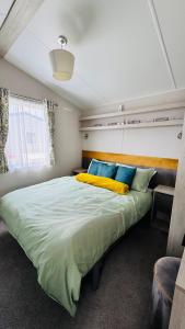 a bedroom with a large bed with yellow pillows at Pure Living -West Sands, Quiet Grassy retreat Seal Bay in Selsey