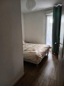 ein kleines Schlafzimmer mit einem Bett und einem Fenster in der Unterkunft Appartement avec piscine in Saint-André