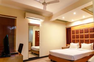 a hotel room with a bed and a television at Bisque Magaji Orchid - Malleshwaram, Near Mantri Square Mall & Majestic in Bangalore +113 photos
