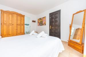 a bedroom with a white bed and a mirror at Villa Pastor in Cala Anguila +38 photos