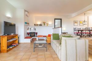 a living room with a couch and a tv at Villa Pastor in Cala Anguila