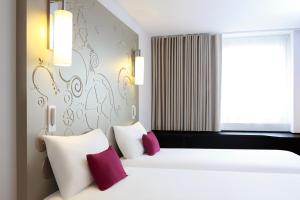a bedroom with a bed with purple and white pillows at VISIONAPARTMENTS Place de Cornavin - self check-in in Geneva +16 photos