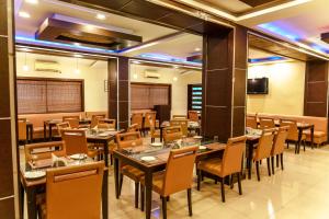 a restaurant with tables and chairs in a room at Bisque Magaji Orchid - Malleshwaram, Near Mantri Square Mall & Majestic in Bangalore