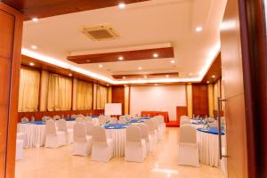 a banquet hall with tables and chairs in a room at Bisque Magaji Orchid - Malleshwaram, Near Mantri Square Mall & Majestic in Bangalore