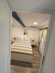 a bedroom with a bed with a striped blanket at Casa lui Matei Murighiol#2 in Murighiol