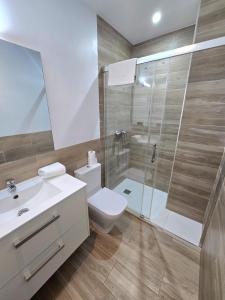 a bathroom with a white toilet and a shower at SM Apartments Station in Lleida