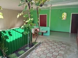 a green room with a table and a bench in it at Валентина in Kurortne