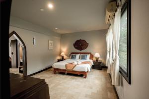 una camera da letto con un letto e una grande finestra di LannaOriental MaeRim a Mae Rim