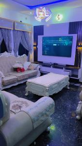 a living room with couches and a large screen tv at Restify luxury apartment and services in Uyo