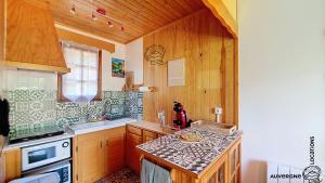 a kitchen with wooden cabinets and a counter top at Chalet Hestia in Murol