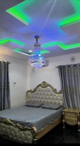 a bedroom with a bed with a chandelier at Restify luxury apartment and services in Uyo