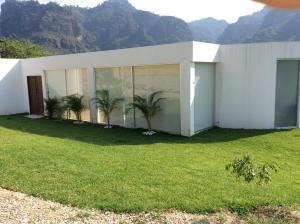 una casa blanca con palmeras en un patio en Casa El Camino, en Amatlán
