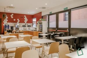 a dining room with tables and chairs in a restaurant at Hotiday Como Paoli in Como