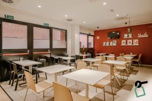 a dining room with white tables and chairs at Hotiday Como Paoli in Como