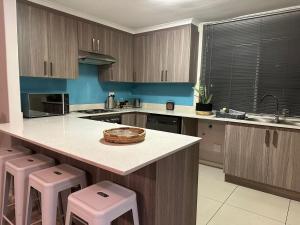 a kitchen with a counter and stools in it at Durbanville Self Catering Apartments in Durbanville