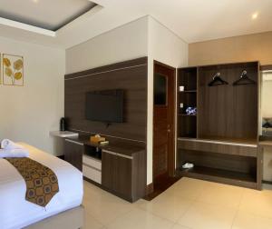 a hotel room with a bed and a television at The Surya Kuta Villa in Kuta