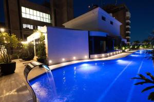 a swimming pool at night with lights on a building at Intercity São Paulo Berrini in São Paulo