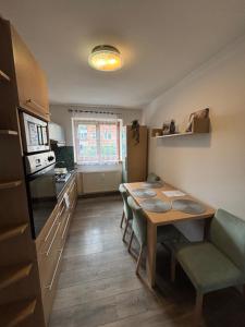 a kitchen with a table and a dining room at Krásny apartmám CENTRUM in Martin