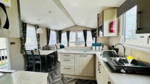 a kitchen and dining area of an rv at Pure Living -West Sands, Quiet Grassy retreat Seal Bay in Selsey +22 photos