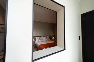 a mirror reflecting a bed in a bedroom at Gaveto de Lisboa - Charming House in Ponta Delgada