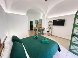 a living room with a green bed and a kitchen at VaSaMi - Appartamento in centro in Bari