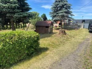 un pequeño cobertizo en un campo junto a una valla en Noclegi Bartodzieje 56, 