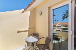 un balcone con 2 sedie e una porta scorrevole in vetro di Casa De Vacaciones La Marinera a Maspalomas