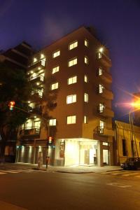 een hoog gebouw in een stadsstraat 's nachts bij Lecer Apart in Buenos Aires