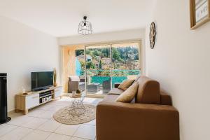 a living room with a couch and a television at quiet studio swimming pool Roquebrune in Roquebrune-Cap-Martin