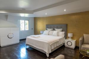a bedroom with a large white bed and a chair at Luxury Vacation Villa in Marbella