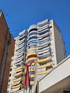 a tall building with a flag in front of it at Sunor Apartments - City Center in Tirana +18 photos