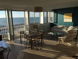 een woonkamer met een bank, een tafel en stoelen bij L'estacade avec sur mer in Le Tréport +57 foto's